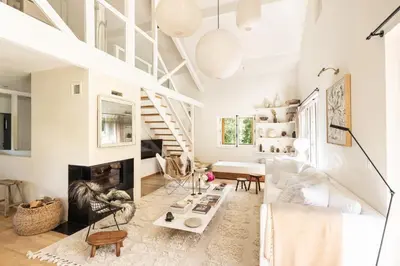 a living room with a fireplace and a staircase at Chalet Hautbois - Family Chalet with 5 Bedrooms with Glacial views CHAMONIX - By Cozee Rentals in Chamonix-Mont-Blanc