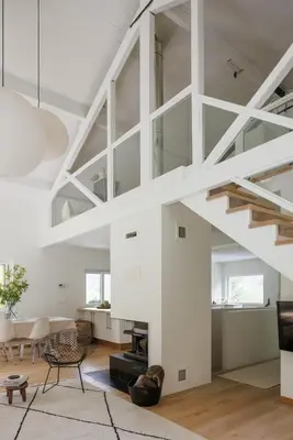 a living room with white walls and a staircase at Chalet Hautbois - Family Chalet with 5 Bedrooms with Glacial views CHAMONIX - By Cozee Rentals in Chamonix-Mont-Blanc