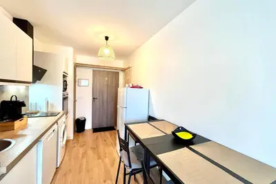 a kitchen with a table and a white refrigerator at Refuge des Prés in Saint-Gervais-les-Bains