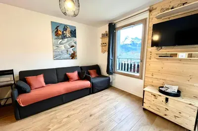 a living room with a couch and a large window at Refuge des Prés in Saint-Gervais-les-Bains