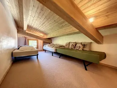 a room with a green couch and a bed at Superbe 3 Pièces avec Balcons en Plein Cœur de Combloux - Parking, Wifi, Lave-linge - FR-1-560-106 in Combloux