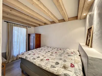 a bedroom with a bed in a room with wooden ceilings at Superbe 3 Pièces avec Balcons en Plein Cœur de Combloux - Parking, Wifi, Lave-linge - FR-1-560-106 in Combloux