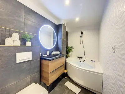 a bathroom with a sink and a tub and a mirror at Évasion Parfaite in Chamonix-Mont-Blanc