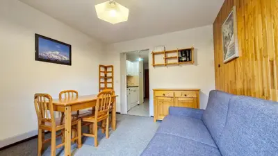 a living room with a blue couch and a table at Appartement Flaine Forêt in Flaine