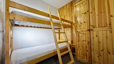 a couple of bunk beds in a room with a ladder at Appartement Flaine Forêt in Flaine