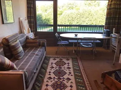 a living room with a couch and a table at Charming Apartment ideal for families in Megève