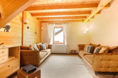 a living room with two couches and a window at L'Ecrin des Pècles - Centrale - Rénové - Immense Terrasse Face au Mont-Blanc in Chamonix-Mont-Blanc