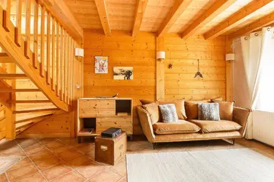 a living room with a couch in a wooden room at L'Ecrin des Pècles - Centrale - Rénové - Immense Terrasse Face au Mont-Blanc in Chamonix-Mont-Blanc