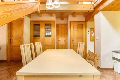a dining room with a wooden table and chairs at L'Ecrin des Pècles - Centrale - Rénové - Immense Terrasse Face au Mont-Blanc in Chamonix-Mont-Blanc