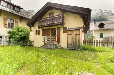 a house with a porch and a wooden door at L'Ecrin des Pècles - Centrale - Rénové - Immense Terrasse Face au Mont-Blanc in Chamonix-Mont-Blanc