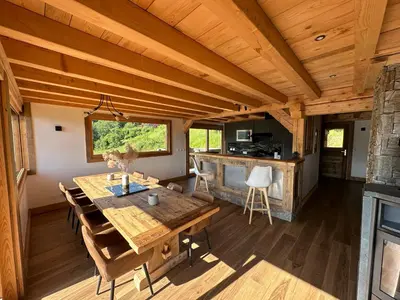 a dining room with a wooden table in a cabin at Chalet vue Mont Blanc avec jacuzzi extérieur in Combloux