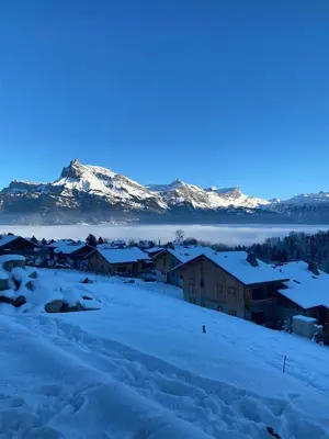 a town covered in snow with mountains in the background at Chalet vue Mont Blanc avec jacuzzi extérieur in Combloux