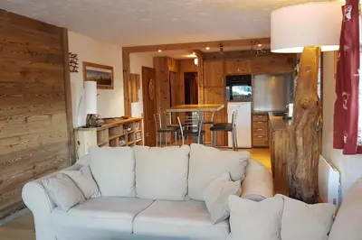 a living room with a white couch and a kitchen at Mon refuge face au Mont Blanc in Saint-Gervais-les-Bains