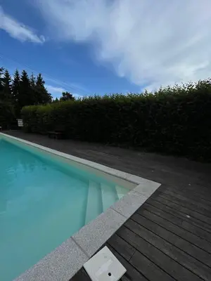 a swimming pool with a bench next to a hedge at Mon refuge face au Mont Blanc in Saint-Gervais-les-Bains
