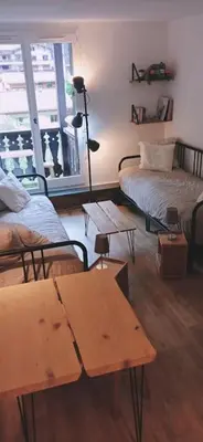 a living room with two beds and a table at Studio élégant à Chamonix in Chamonix-Mont-Blanc