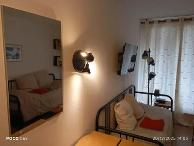 a bedroom with a crib and a mirror and a bed at Studio élégant à Chamonix in Chamonix-Mont-Blanc
