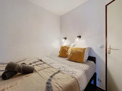 a bedroom with a bed with two lamps on it at P'tiot Chamois Appartement Chamonix, Parking in Chamonix-Mont-Blanc