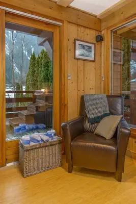 a living room with a leather chair and a window at Chalet Chardonnet in Chamonix-Mont-Blanc