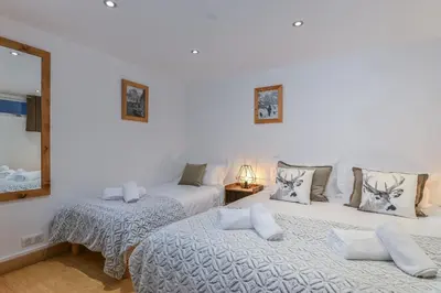 a bedroom with two beds and a mirror at Chalet Chardonnet in Chamonix-Mont-Blanc