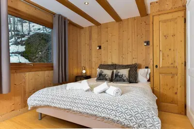 a bedroom with a large bed with wooden walls at Chalet Chardonnet in Chamonix-Mont-Blanc