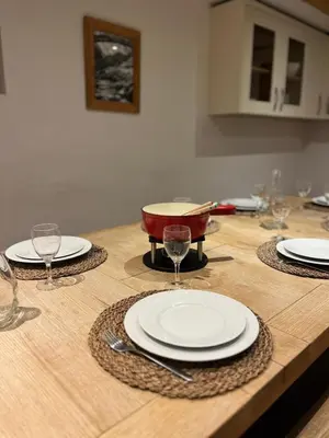 a wooden table with plates and wine glasses on it at Chalet Chardonnet in Chamonix-Mont-Blanc