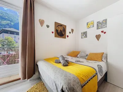 a bedroom with a bed and a desk and a kitchen at STUDIO LIMBO CHAMONIX HYPER CENTRE Vue imprenable sur le Mont-blanc in Chamonix-Mont-Blanc