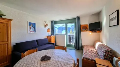 a living room with a blue couch and a table at Résidence Gemeaux - Studio confortable · Centre station · Balcon MAE-7844 in Magland