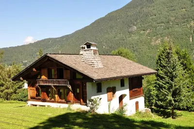 a small house in a field with a mountain at Chalet de charme - 8 pers - 140m2 - Jardin - Calme in Les Houches