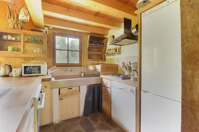 a kitchen with wooden cabinets and a white refrigerator at Chalet de charme - 8 pers - 140m2 - Jardin - Calme in Les Houches