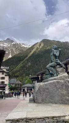 a statue of a woman sitting on a rock in front of a mountain at Abeille de Chamonix in Chamonix-Mont-Blanc