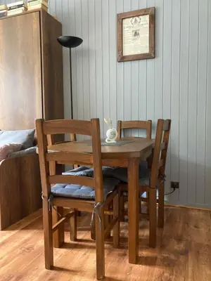a wooden dining room table with two chairs and a lamp at Abeille de Chamonix in Chamonix-Mont-Blanc