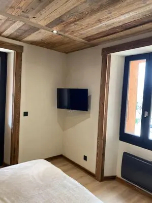 a bedroom with a bed and a tv on the wall at Appartement Saint-Gervais-Les-Bains in Saint-Gervais-les-Bains