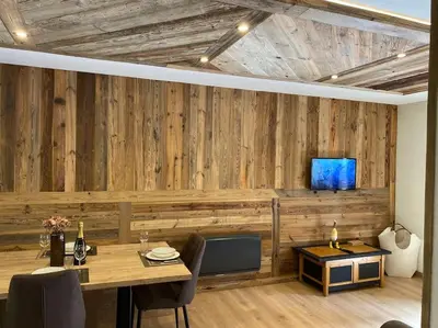 a dining room with a table and a tv on a wall at Appartement Saint-Gervais-Les-Bains in Saint-Gervais-les-Bains