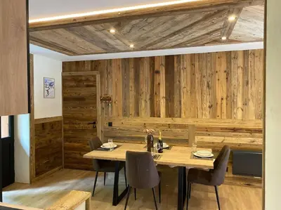 a dining room with a wooden wall with a table and chairs at Appartement Saint-Gervais-Les-Bains in Saint-Gervais-les-Bains