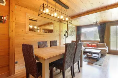 a dining room with a table and chairs and a couch at Maison Neuve - Ski aux pieds - Vue Mt-Blanc in Les Houches