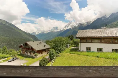 a view of a house with mountains in the background at Maison Neuve - Ski aux pieds - Vue Mt-Blanc in Les Houches