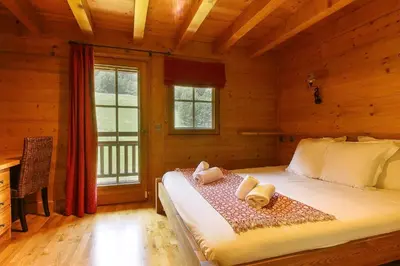 a bedroom with a bed in a log cabin at Maison Neuve - Ski aux pieds - Vue Mt-Blanc in Les Houches
