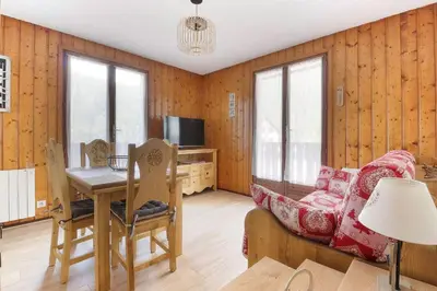 a living room with a couch and a table at La Griaz - Chaleureux et cosy -Vue sur les montagnes - grand balcon in Les Houches