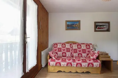 a living room with a bed and a window at La Griaz - Chaleureux et cosy -Vue sur les montagnes - grand balcon in Les Houches