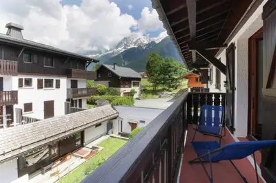 a balcony with chairs and a view of a mountain at La Griaz - Chaleureux et cosy -Vue sur les montagnes - grand balcon in Les Houches