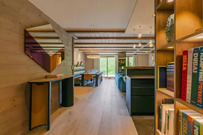 a room with wooden walls and a staircase with books at Rochebrune - Appartement de luxe in Megève