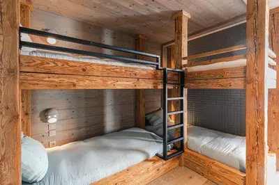 two bunk beds in a cabin with wooden walls at Rochebrune - Appartement de luxe in Megève