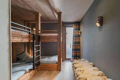 a room with two bunk beds and a window at Rochebrune - Appartement de luxe in Megève