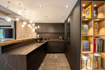 a kitchen with black cabinets and a counter at Rochebrune - Appartement de luxe in Megève