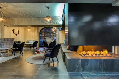 a lobby with a fireplace and chairs at Apartment Chéserys, Alpes Travel, Les Praz Sleeps 2-4 in Chamonix-Mont-Blanc