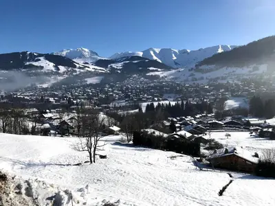 a town in the snow with mountains in the background at Confortable 3 pièces à Megève avec Wi-Fi et garage à skis - FR-1-453-306 in Megève