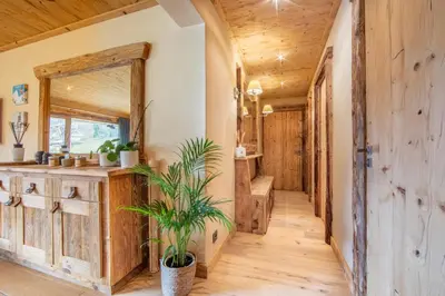 a hallway in a log cabin with wooden floors and a mirror at Les Corneilles - Appartement in Megève