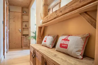 two pillows sitting on a wooden bench in a hallway at Les Corneilles - Appartement in Megève