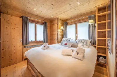 a bedroom with a large bed in a log cabin at Les Corneilles - Appartement in Megève