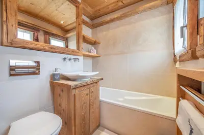 a bathroom with a toilet and a tub and a sink at Les Corneilles - Appartement in Megève